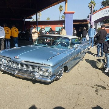 Chevrolet Impala z 1959 roku w srebrnym błękicie – gwiazda zlotu w tłumie fanów