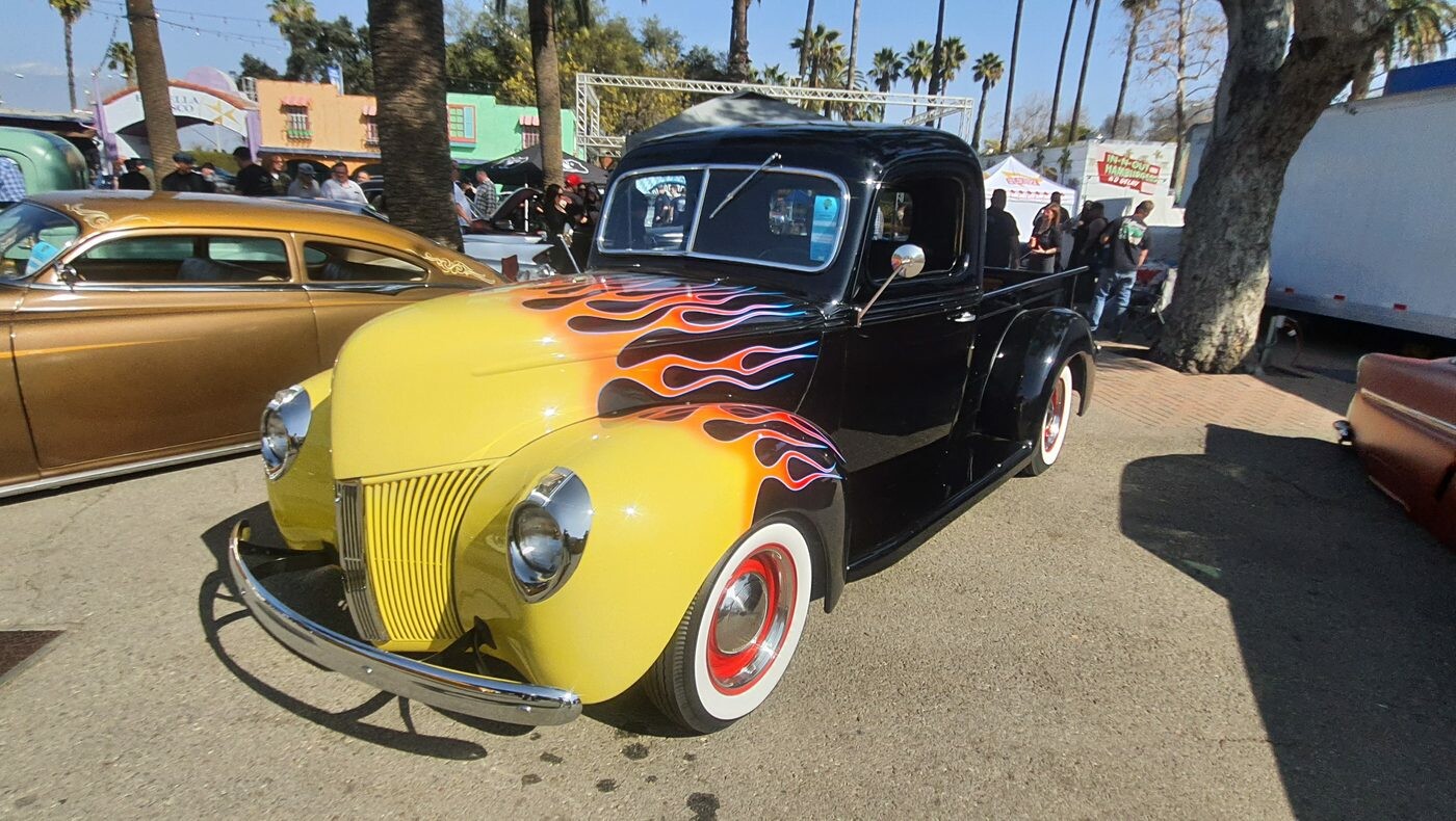Czarny Ford coupe z 1940 roku w płomieniach – hot rod na czerwonych felgach