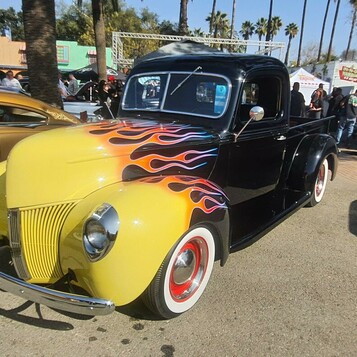 Czarny Ford coupe z 1940 roku w płomieniach – hot rod na czerwonych felgach