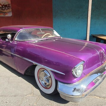 Purpurowy Oldsmobile z połowy lat 50. – candy kustom z szeroką chromowaną atrapą