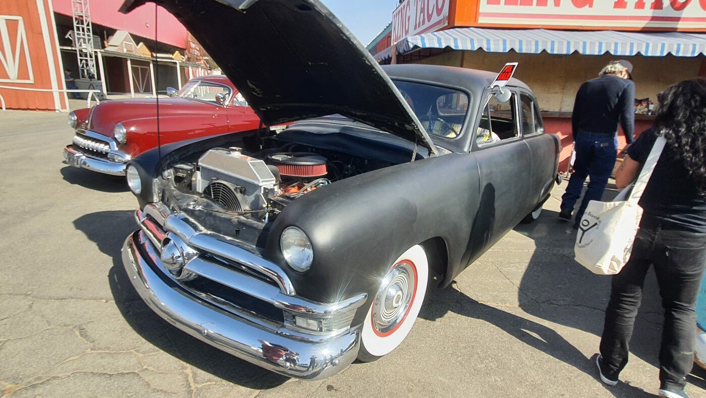 Matowy czarny Ford z 1950 roku z kompresorem – shoebox, który pokazuje silnik