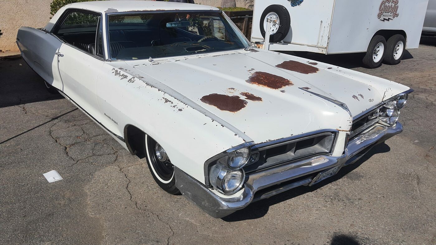 Biały Pontiac z połowy lat 60. w patynie – pionowe reflektory i rdza na masce