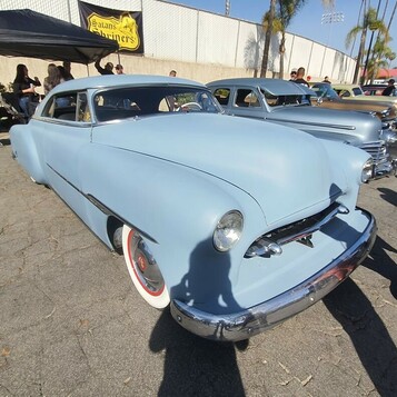 Jasnoniebieski Chevrolet Bel Air z 1953 roku – kustom z wpuszczonymi reflektorami i gładkim przodem