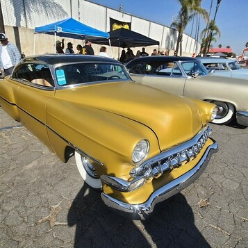 Złoty Chevrolet z 1954 roku – kustom w kolorze musztardy z chromowanym zderzakiem
