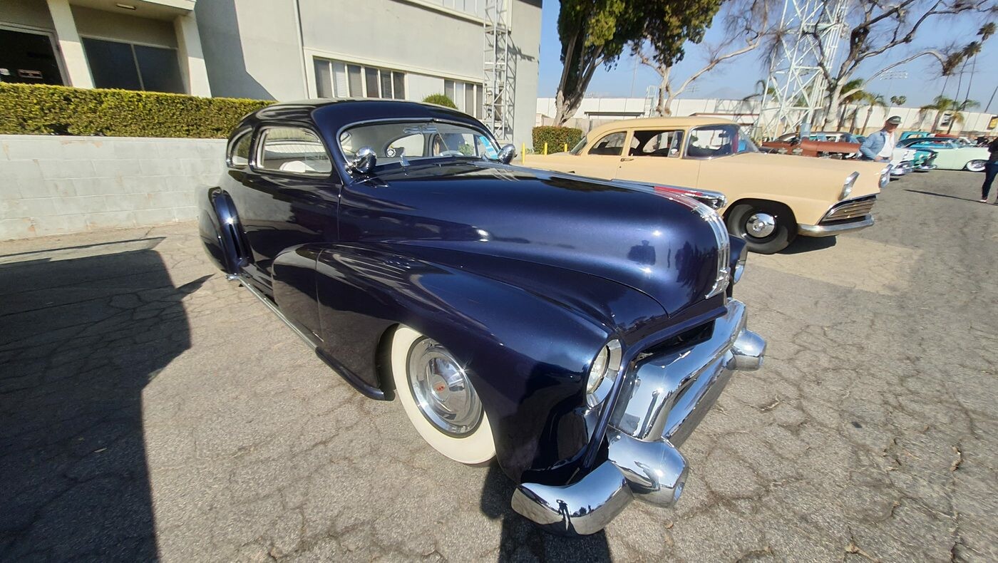 Granatowe Chevrolet coupe z 1941 roku – przedwojenna sylwetka na szerokich białych ściankach