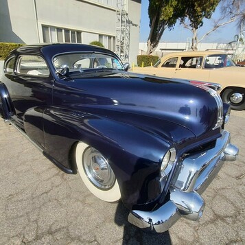 Granatowe Chevrolet coupe z 1941 roku – przedwojenna sylwetka na szerokich białych ściankach
