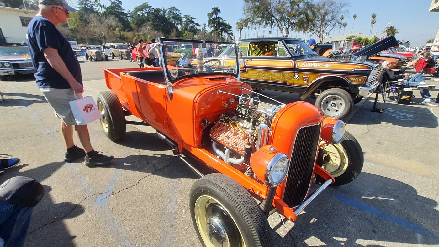 Pomarańczowy roadster pickup Forda z lat 20. – hot rod ze złotymi akcentami i odsłoniętym silnikiem