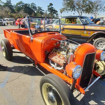 Pomarańczowy roadster pickup Forda z lat 20. – hot rod ze złotymi akcentami i odsłoniętym silnikiem
