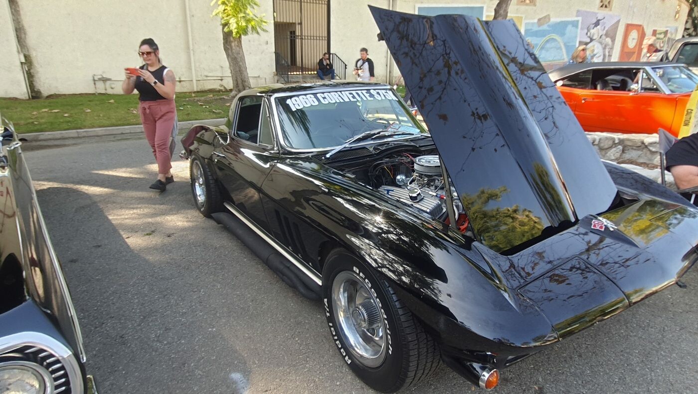 Czarny Chevrolet Corvette z 1966 roku – Sting Ray z otwartą maską i tablicą „NIXON 66”