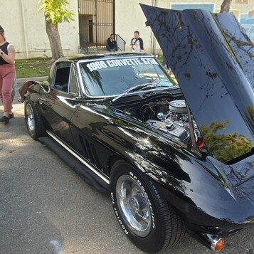 Czarny Chevrolet Corvette z 1966 roku – Sting Ray z otwartą maską i tablicą „NIXON 66”