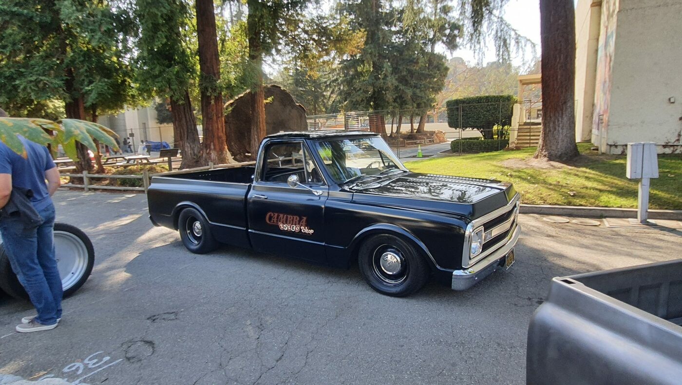 Czarny Chevrolet C10 z lat 1967–72 – obniżony pickup z czerwonymi napisami na drzwiach