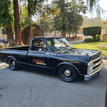 Czarny Chevrolet C10 z lat 1967–72 – obniżony pickup z czerwonymi napisami na drzwiach