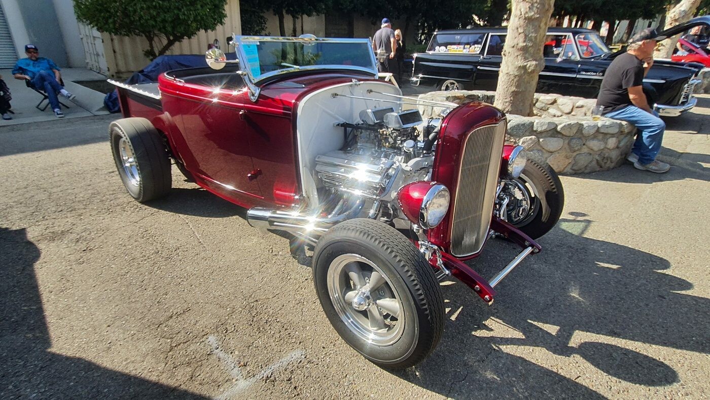 Candy red Ford roadster z 1932 roku – Deuce highboy z chromowanym silnikiem przed Muzeum NHRA