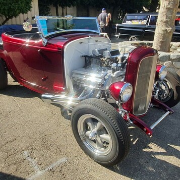 Candy red Ford roadster z 1932 roku – Deuce highboy z chromowanym silnikiem przed Muzeum NHRA