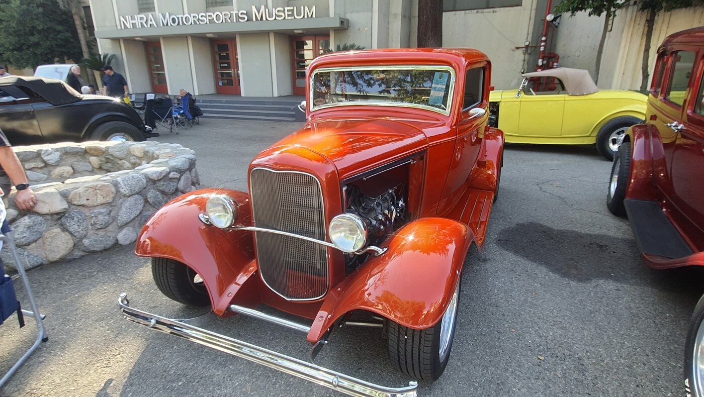 Pomarańczowo-czerwony Ford 3-window coupe z 1932 roku – Deuce w kolorze tangerine przed Muzeum NHRA