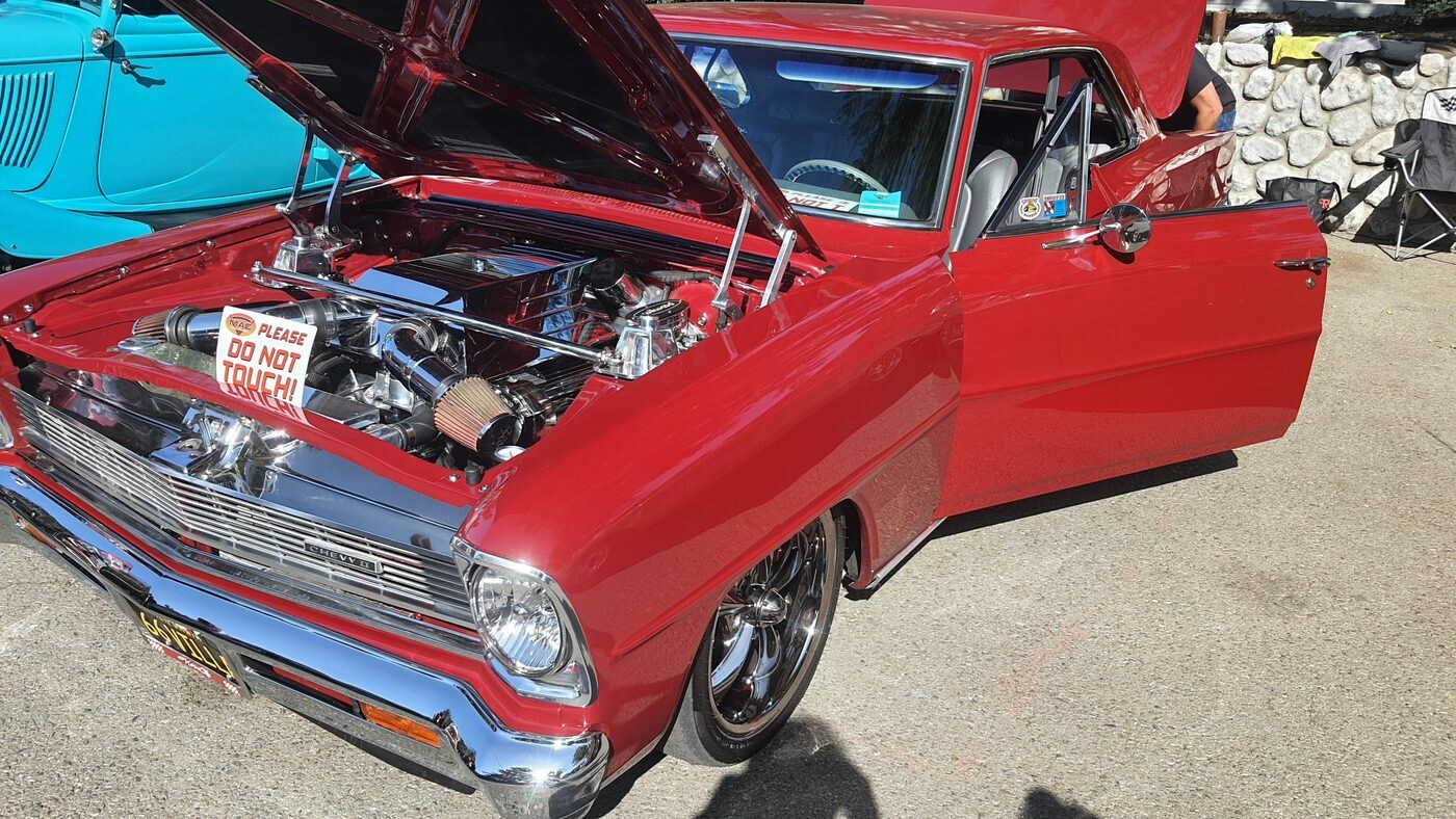 Czerwony Chevrolet Nova z 1966 roku z otwartą maską – kompaktowy muscle car z chromowanym silnikiem