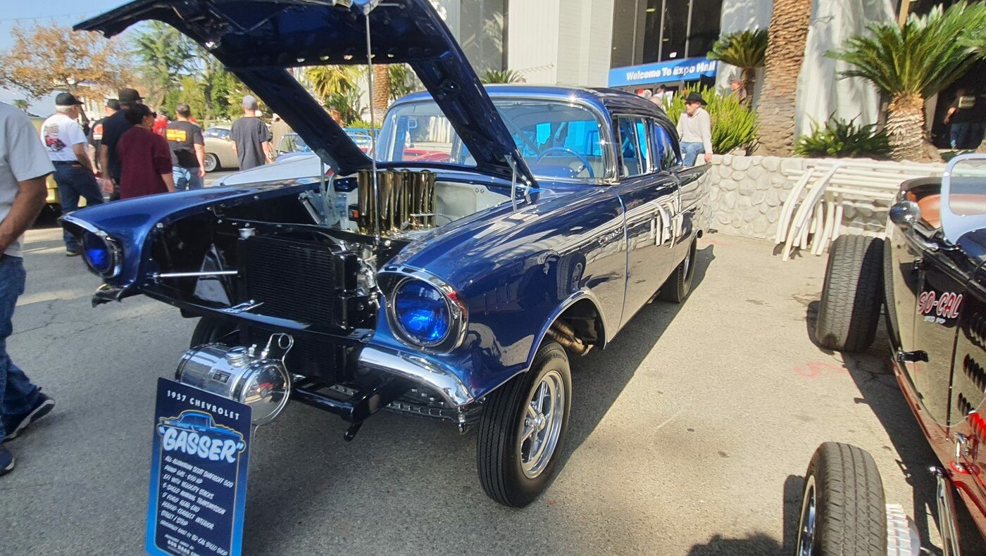 Granatowy Chevrolet z 1957 roku jako gasser – wtrysk Hilborn z chromowanymi lejkami pod otwartą maską