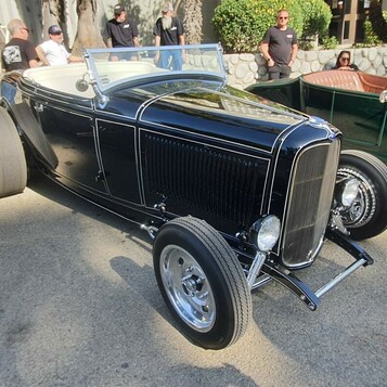 Czarny Ford roadster z 1932 roku z beżowym wnętrzem – Deuce highboy w rzędzie roadsterów