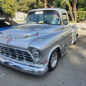 Srebrny Chevrolet Task Force z malowanymi kwiatami – pickup z lat 50. z artystycznym lakierem