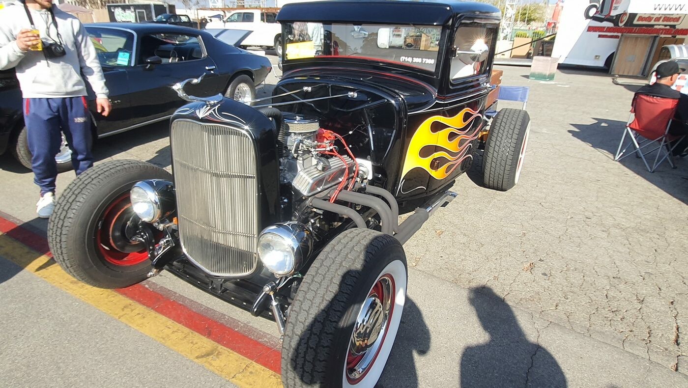 Czarny Ford pickup z 1932 roku w płomieniach – hot rod z odsłoniętym silnikiem i czerwonymi felgami