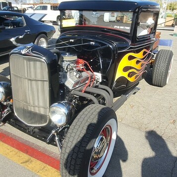 Czarny Ford pickup z 1932 roku w płomieniach – hot rod z odsłoniętym silnikiem i czerwonymi felgami