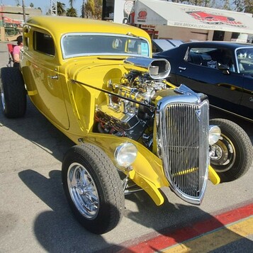 Żółty Ford 3-window coupe z 1934 roku – highboy z odsłoniętym silnikiem w kolorze słońca