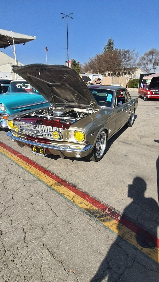 Złoty Chevrolet Chevelle z 1967 roku z otwartą maską – muscle car z żółtymi reflektorami