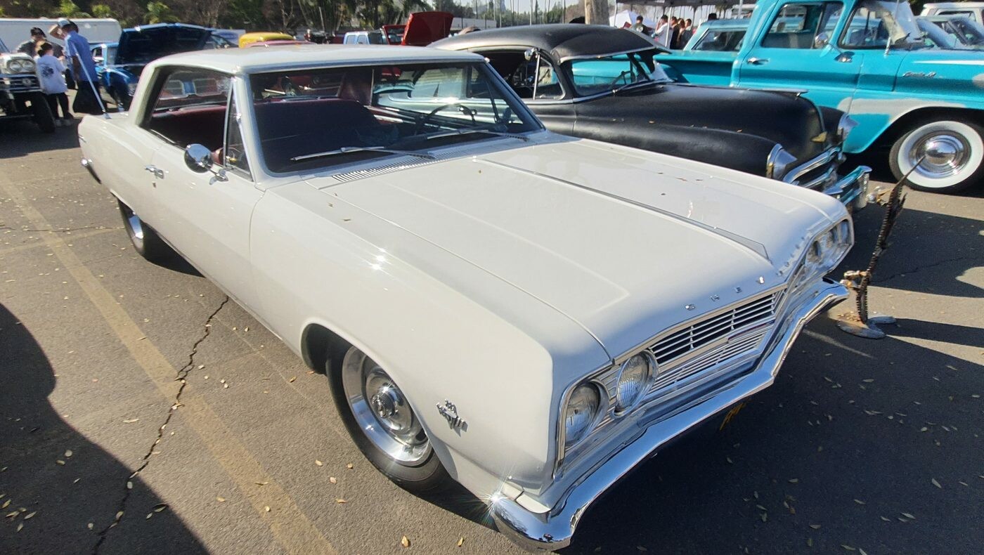 Biały Chevrolet Chevelle Malibu z 1965 roku z czarnym dachem – hardtop na chromowanych kołpakach