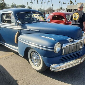 Niebieski Mercury Eight coupe z 1947 roku – powojenny klasyk z pionową atrapą, z przodu i z tyłu