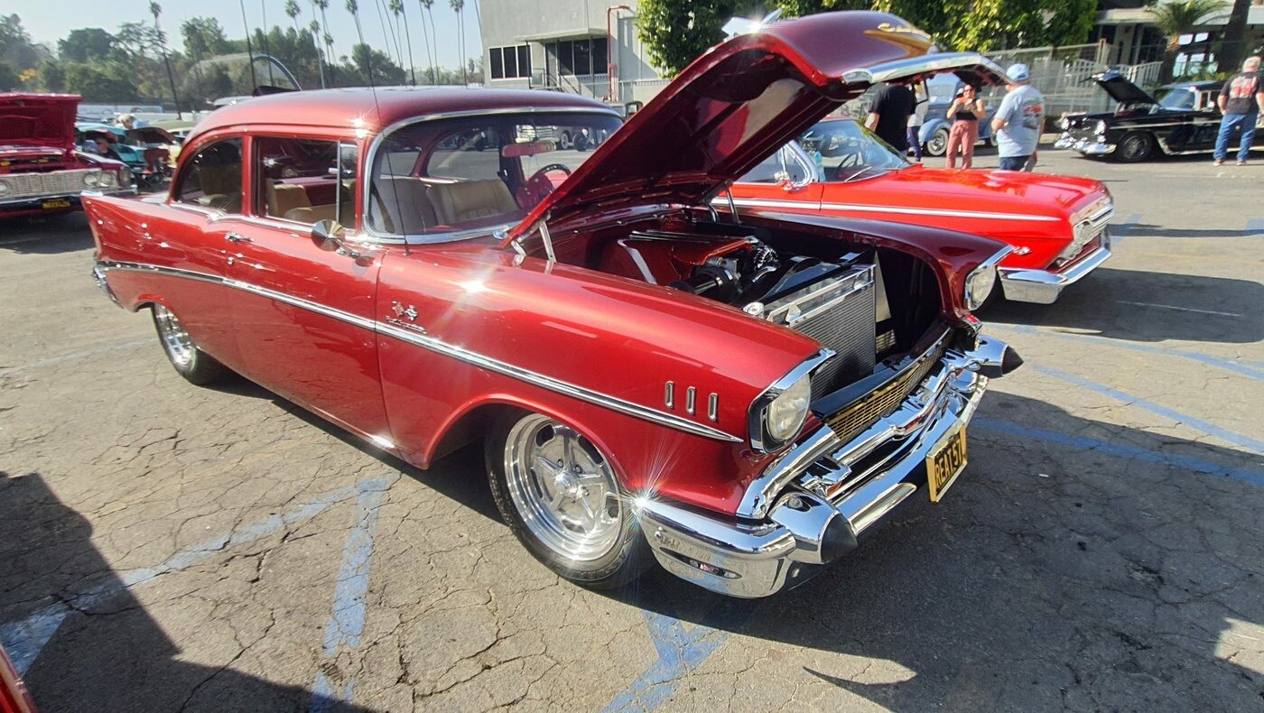 Czerwony Chevrolet Bel Air z 1957 roku z otwartą maską – „57 Chevy” na chromowanych felgach