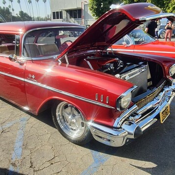 Czerwony Chevrolet Bel Air z 1957 roku z otwartą maską – „57 Chevy” na chromowanych felgach