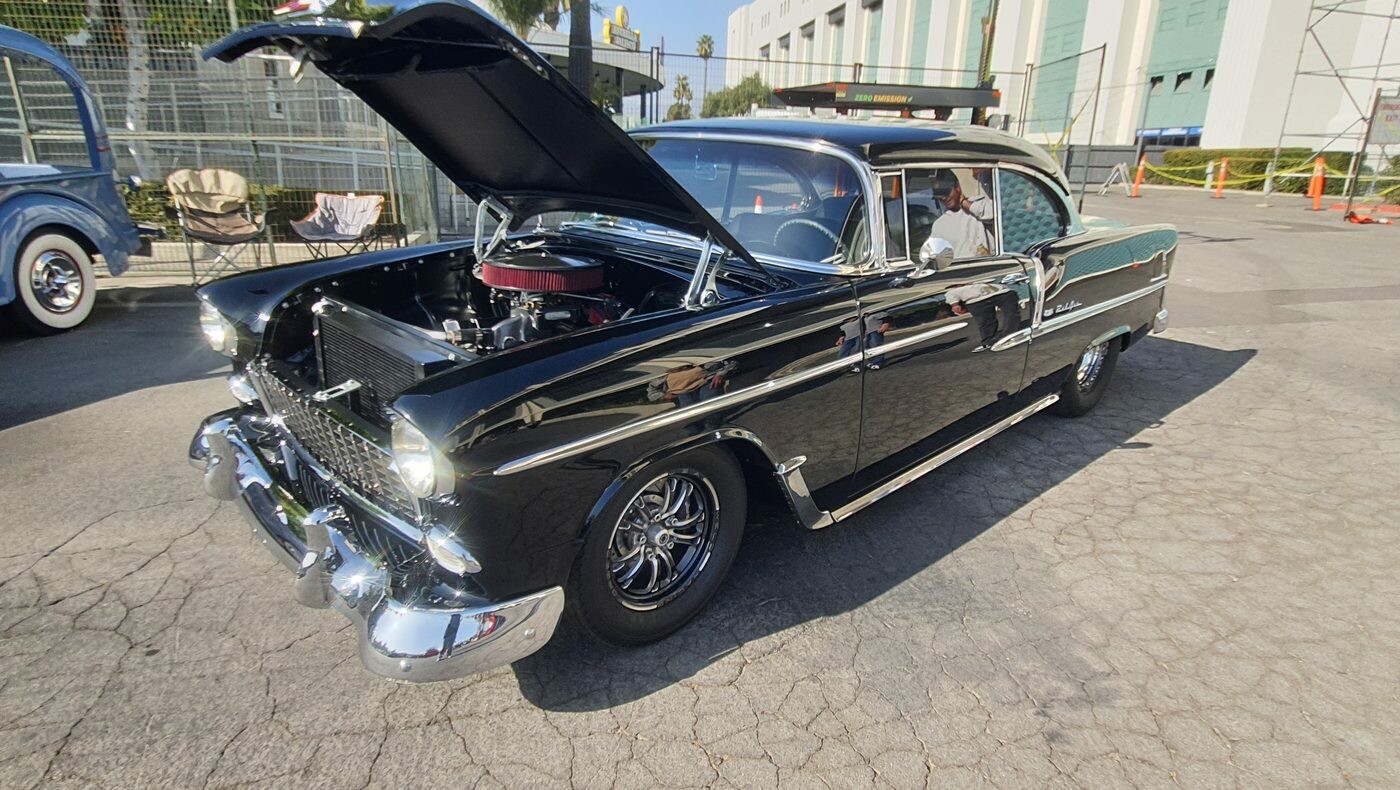 Czarny Chevrolet Bel Air z 1955 roku z otwartą maską – „55 Chevy” na czarnych felgach z obu stron
