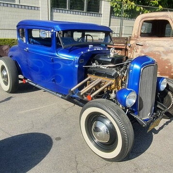 Niebieski Ford 5-window coupe z 1932 roku z silnikiem na wierzchu – hot rod na szerokich białych ściankach