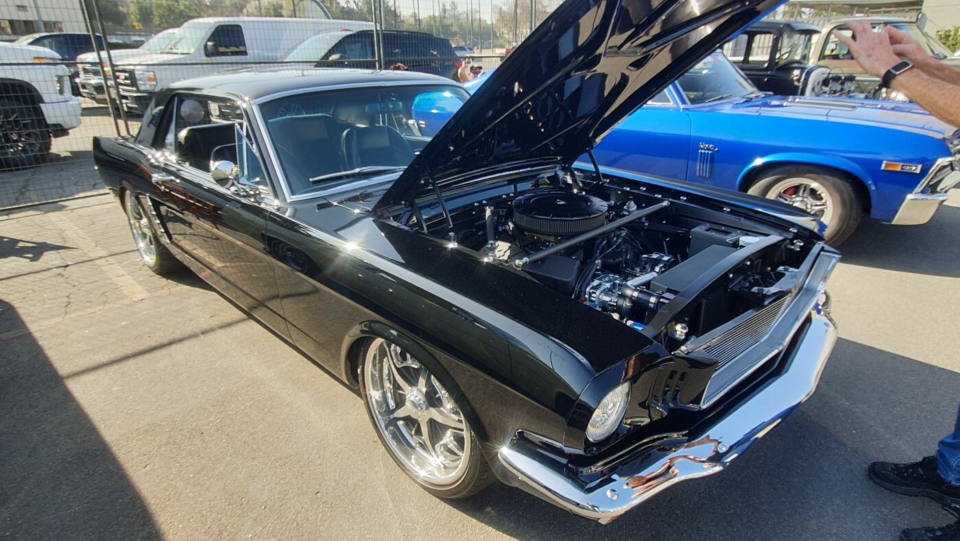 Czarny Ford Mustang z 1966 roku restomod – lustrzany lakier, otwarta maska i nowoczesny silnik