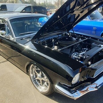 Czarny Ford Mustang z 1966 roku restomod – lustrzany lakier, otwarta maska i nowoczesny silnik