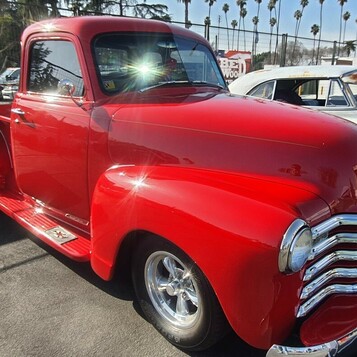 Czerwony Chevrolet 3100 Advance Design z 1951 roku – pickup z chromowaną atrapą na chromowanych felgach