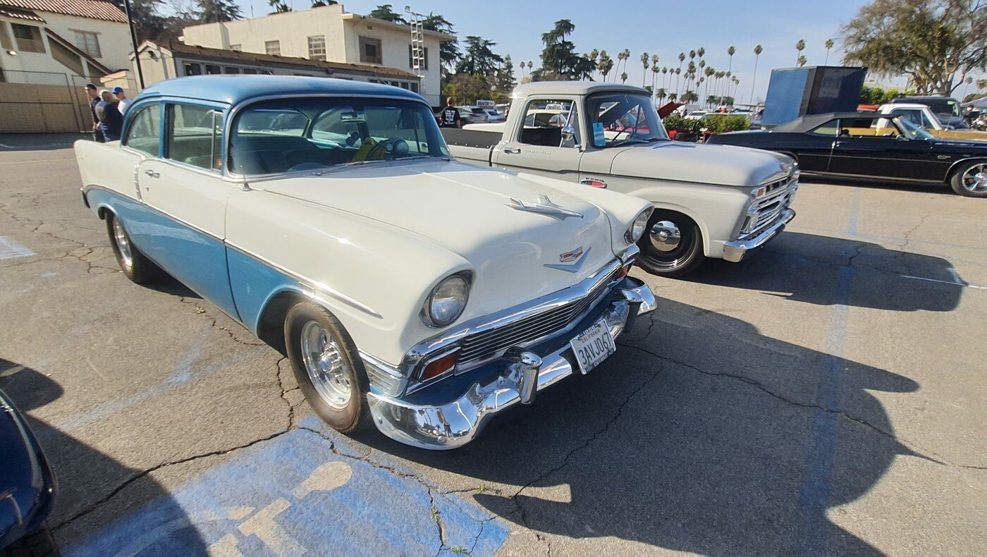 Biało-turkusowy Chevrolet 210 z 1956 roku – dwudrzwiowy sedan na białych ściankach
