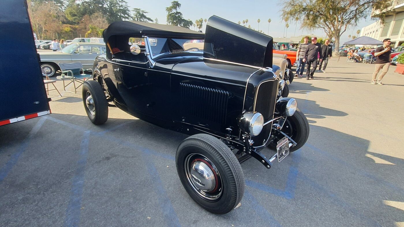 Czarny Ford roadster z 1932 roku z podniesionym dachem – Deuce highboy na czerwonych felgach
