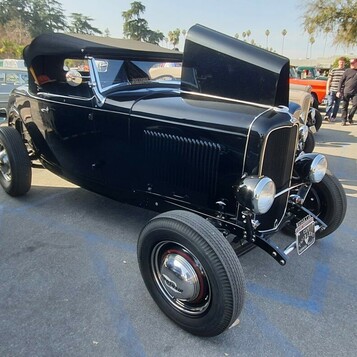 Czarny Ford roadster z 1932 roku z podniesionym dachem – Deuce highboy na czerwonych felgach