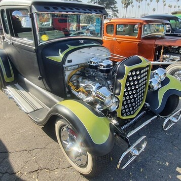 Czarny Ford Model A coupe z limonkowymi płomieniami – hot rod z chromowanym silnikiem i złotą atrapą