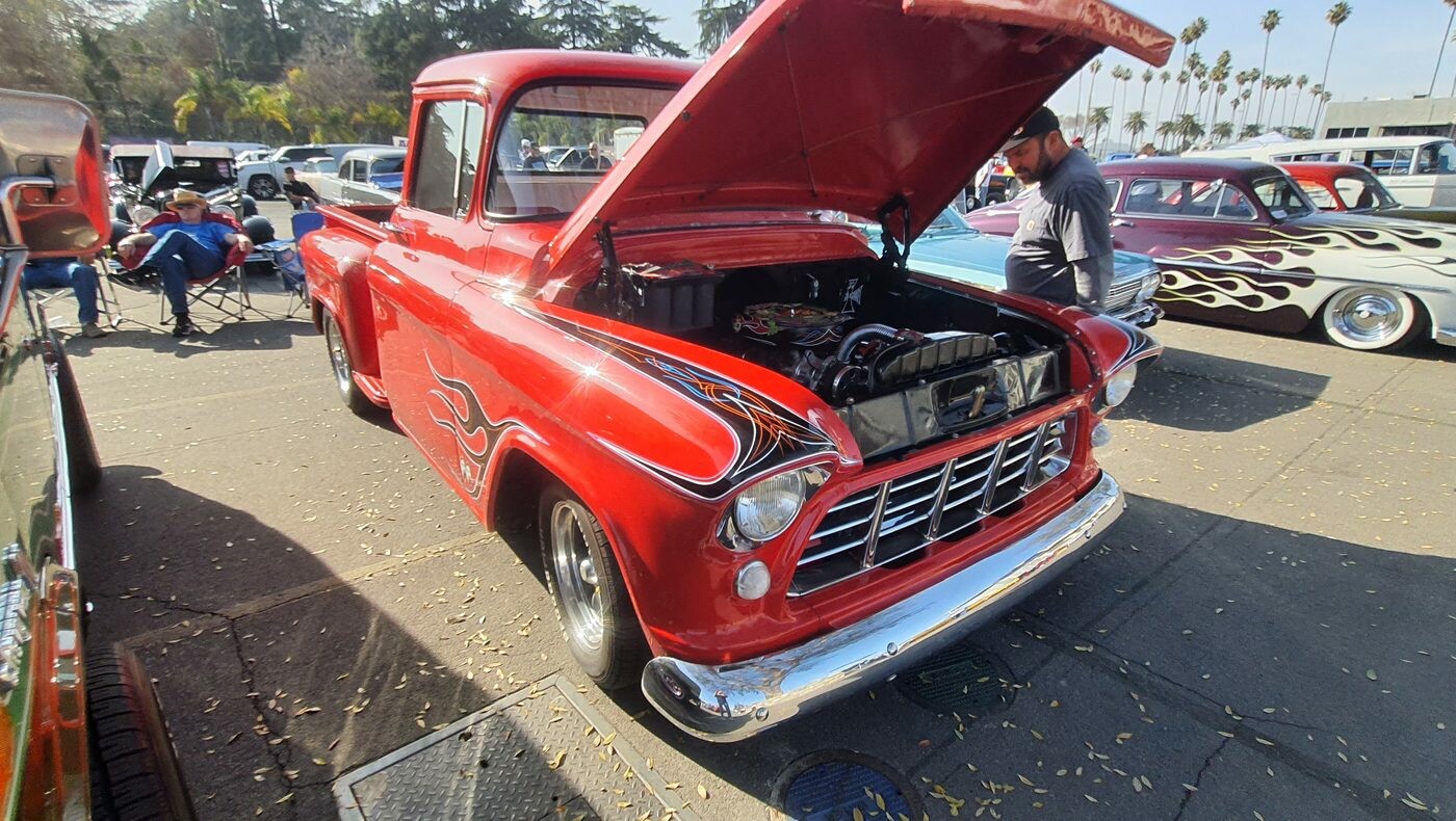 Czerwony Chevrolet 3100 Task Force z 1956 roku z czarnymi płomieniami – pickup z otwartą maską
