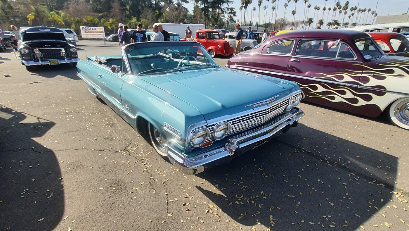 Turkusowy Chevrolet Impala kabriolet z 1963 roku – lowrider z opuszczonym dachem na chromowanych kołpakach