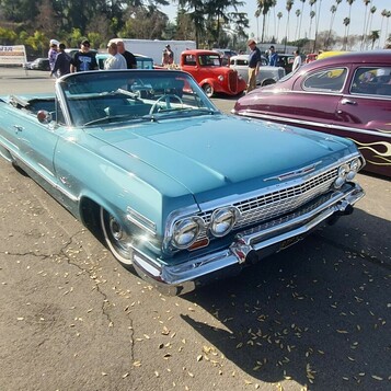 Turkusowy Chevrolet Impala kabriolet z 1963 roku – lowrider z opuszczonym dachem na chromowanych kołpakach