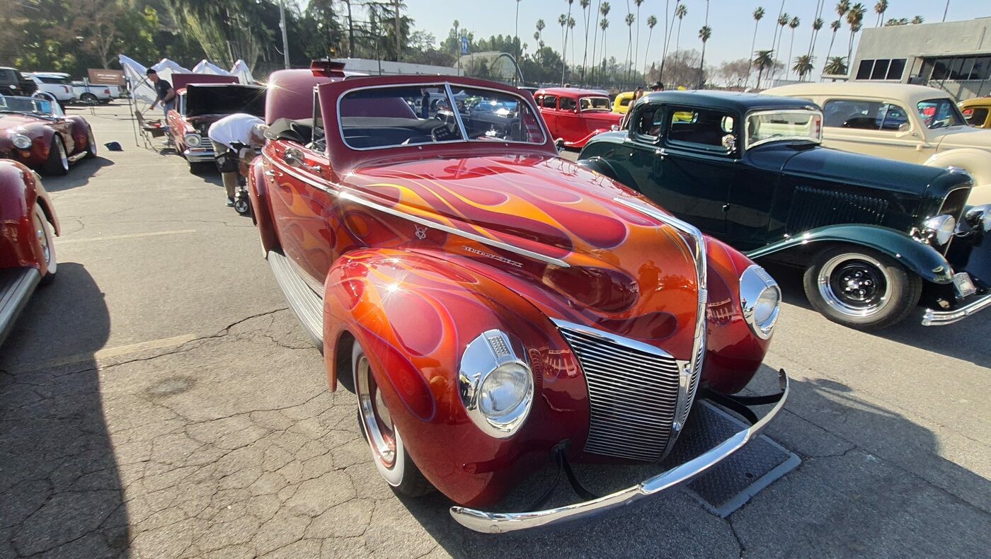 Czerwony Ford Deluxe coupe z 1940 roku w pomarańczowo-żółtych płomieniach – kustom w ogniu