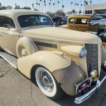 Beżowy Buick Special z 1937 roku – przedwojenny sedan z atrapą wodospadową na szerokich białych ściankach
