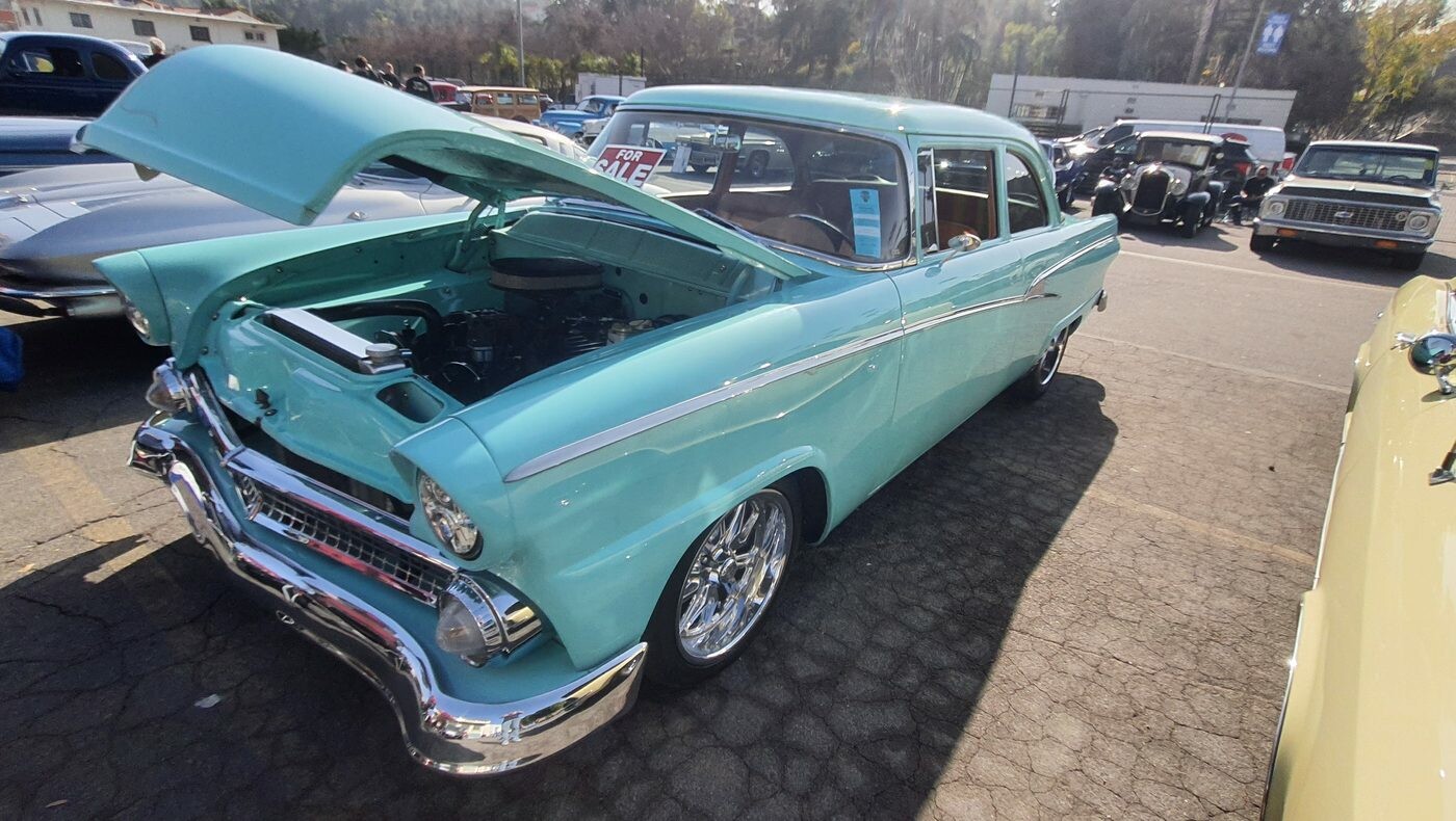 Turkusowy Ford Fairlane z 1955 roku z otwartą maską – dwudrzwiowy sedan z chromowaną kratką na polerowanych felgach