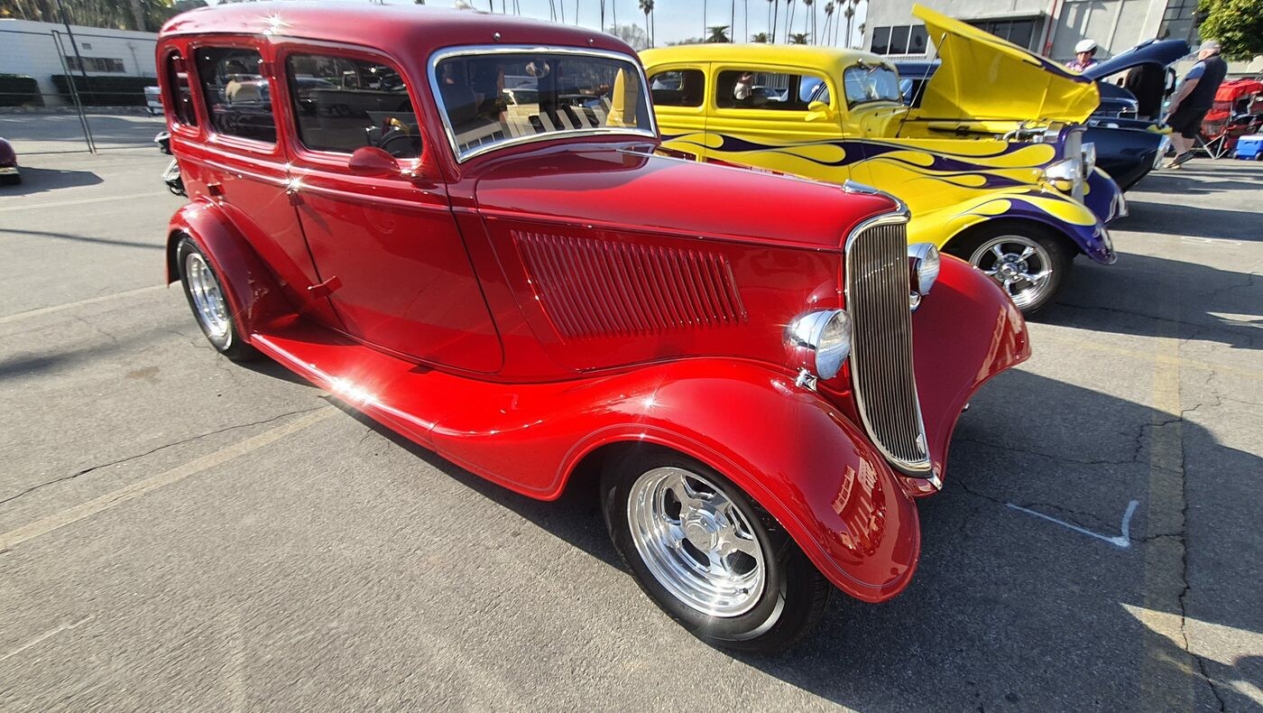 Czerwony Ford Tudor sedan z 1934 roku – przedwojenny street rod z pochyloną atrapą na polerowanych felgach