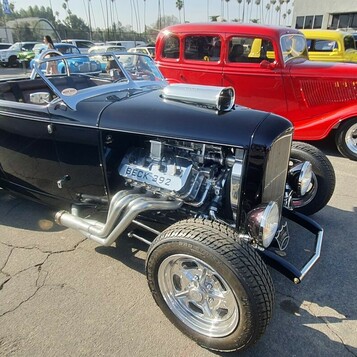 Czarny Ford roadster z 1932 roku z chromowanym silnikiem i bocznymi rurami – Deuce highboy w stylu show rod