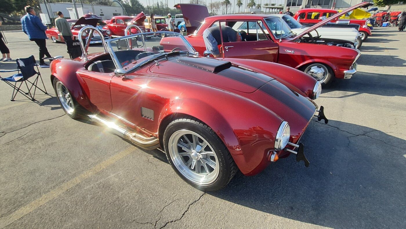 Czerwona Shelby Cobra 427 – roadster z bocznymi rurami i pałąkiem na polerowanych felgach