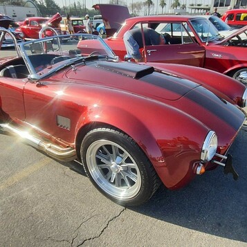 Czerwona Shelby Cobra 427 – roadster z bocznymi rurami i pałąkiem na polerowanych felgach